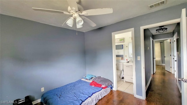 bedroom with ceiling fan, ensuite bathroom, and hardwood / wood-style flooring