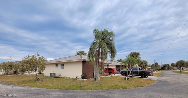 view of home's exterior with central AC unit and a yard