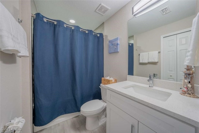 bathroom featuring toilet, vanity, walk in shower, and hardwood / wood-style floors