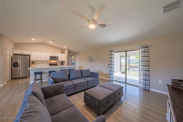 living room featuring ceiling fan and lofted ceiling