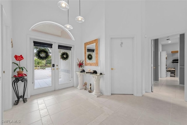 tiled foyer featuring a high ceiling and french doors