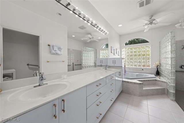 bathroom with ceiling fan, vanity, tile patterned floors, and tiled tub