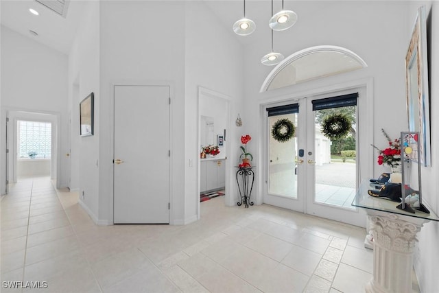 tiled foyer with a healthy amount of sunlight, french doors, and a high ceiling