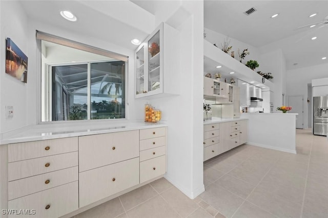 kitchen featuring ceiling fan, white cabinets, stainless steel fridge with ice dispenser, and light tile patterned floors