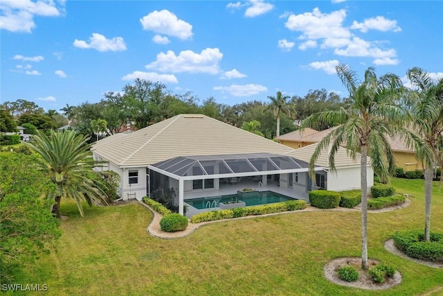 back of property with a lanai and a lawn