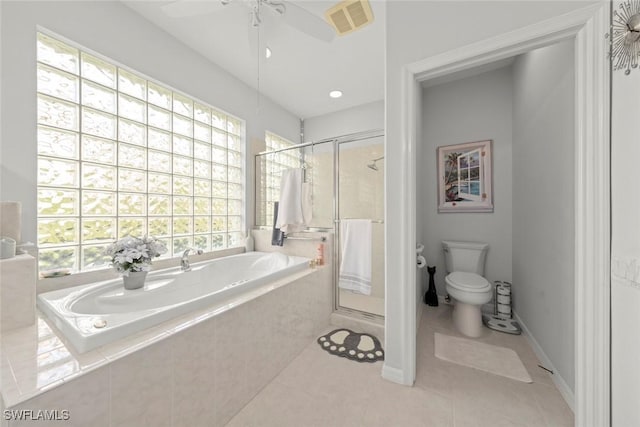 bathroom with plus walk in shower, toilet, a wealth of natural light, and tile patterned flooring