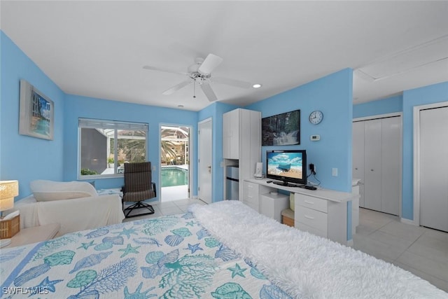 tiled bedroom featuring ceiling fan, access to exterior, and multiple closets