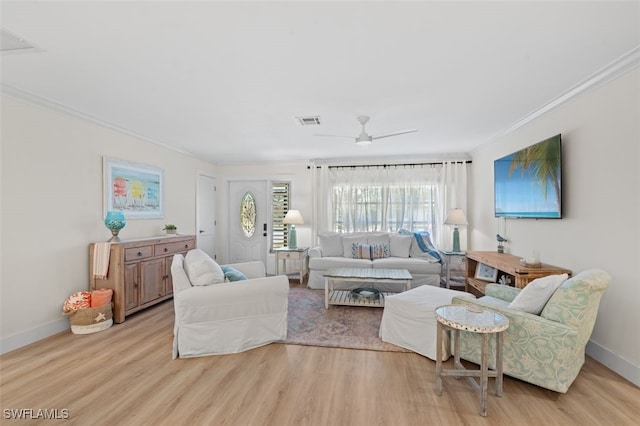 living room featuring ornamental molding, ceiling fan, and light wood-type flooring