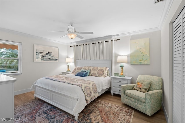 bedroom with hardwood / wood-style flooring, ornamental molding, and ceiling fan