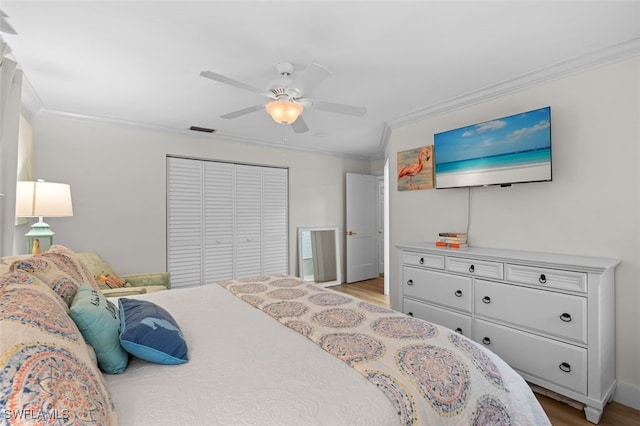 bedroom featuring ornamental molding, a closet, ceiling fan, and light wood-type flooring