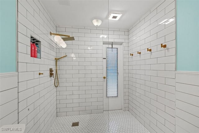 bathroom with tiled shower and tile walls