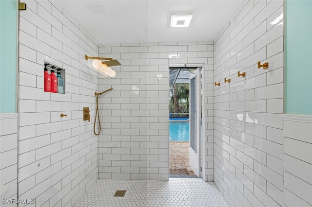 bathroom with tiled shower and tile walls