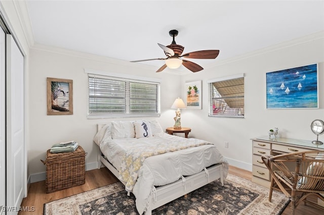 bedroom with ornamental molding, wood-type flooring, and ceiling fan