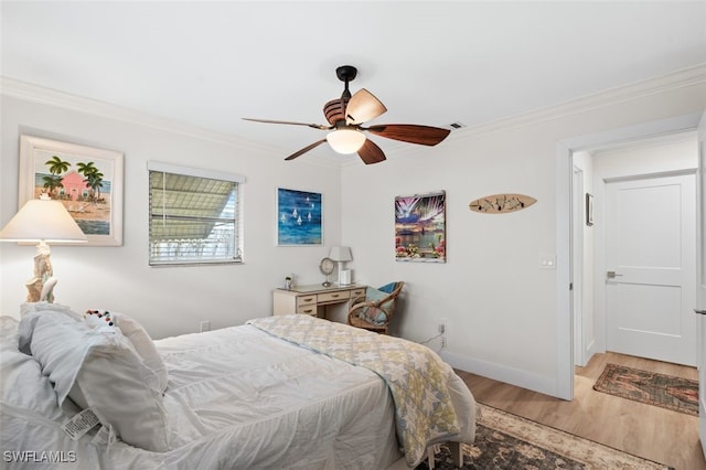 bedroom featuring hardwood / wood-style flooring, ornamental molding, and ceiling fan