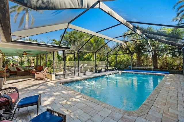 view of pool with a lanai, outdoor lounge area, a patio, and ceiling fan