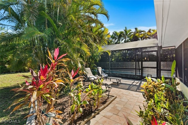 view of patio featuring a swimming pool and glass enclosure