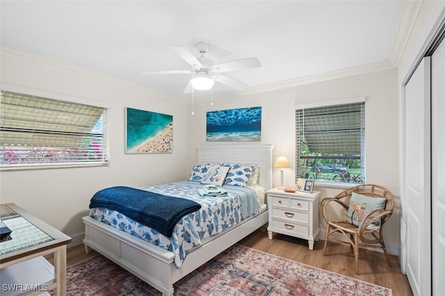 bedroom with crown molding, ceiling fan, hardwood / wood-style floors, and a closet