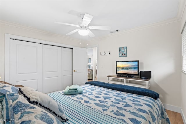 bedroom featuring ornamental molding, hardwood / wood-style floors, ceiling fan, and a closet