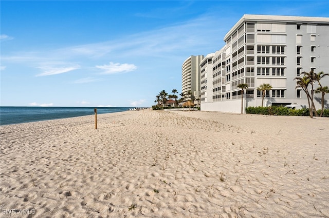 surrounding community featuring a view of the beach, volleyball court, and a water view