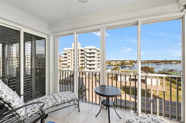 sunroom featuring a water view