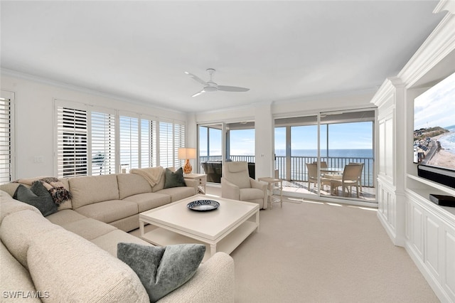 living room featuring crown molding, light colored carpet, ceiling fan, and a water view