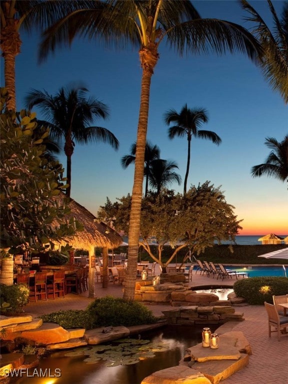 pool at dusk with a patio