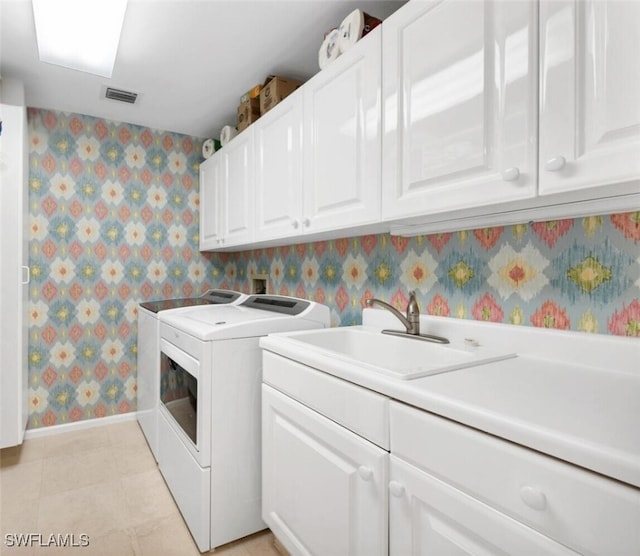 laundry area with cabinets, separate washer and dryer, sink, and light tile patterned floors