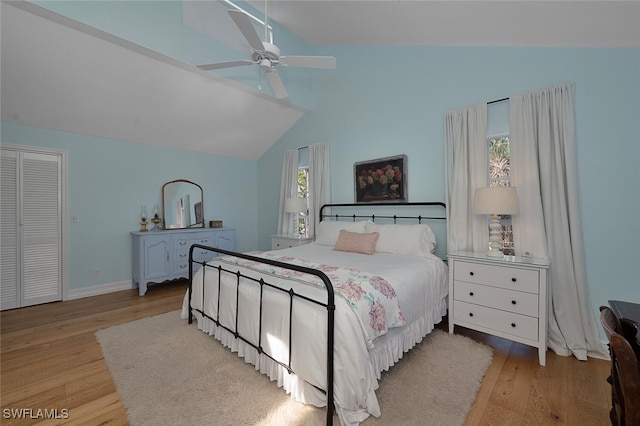 bedroom featuring lofted ceiling, light hardwood / wood-style flooring, a closet, and ceiling fan