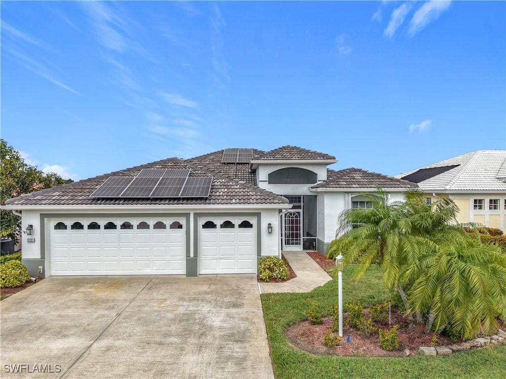 view of front of home featuring a garage and solar panels