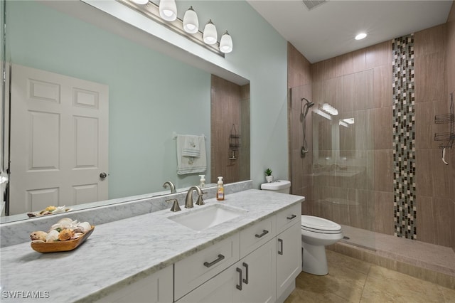 bathroom with vanity, a shower with shower door, tile patterned floors, and toilet