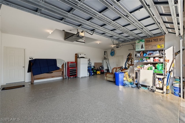 garage featuring white refrigerator and a garage door opener