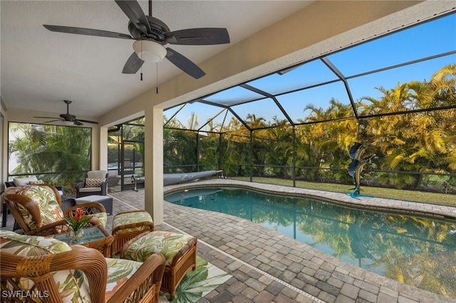 view of pool with a patio, a lanai, outdoor lounge area, and ceiling fan