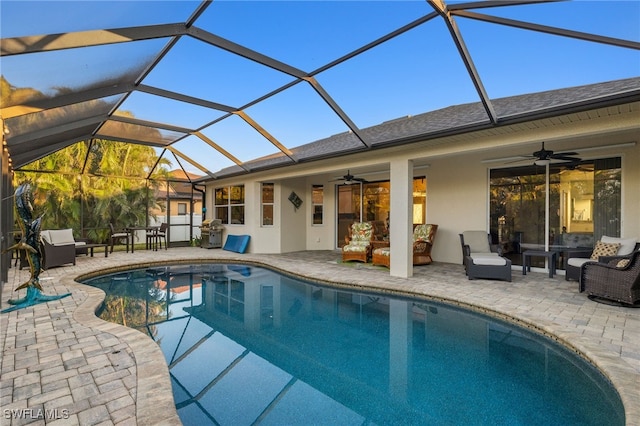 view of pool featuring ceiling fan, outdoor lounge area, a patio area, and glass enclosure