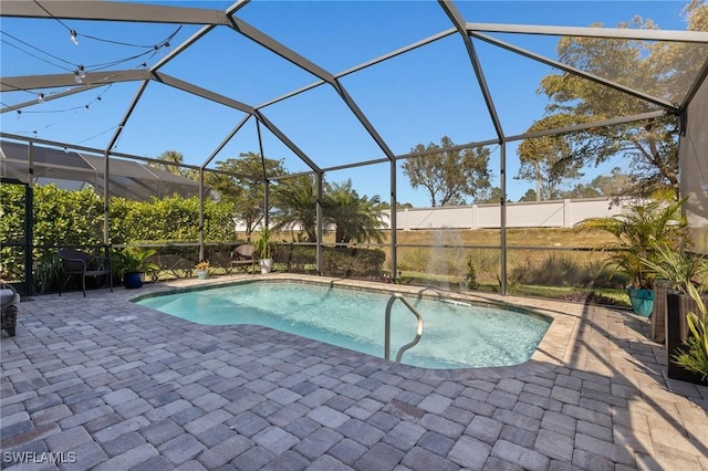 view of swimming pool featuring a patio area and glass enclosure