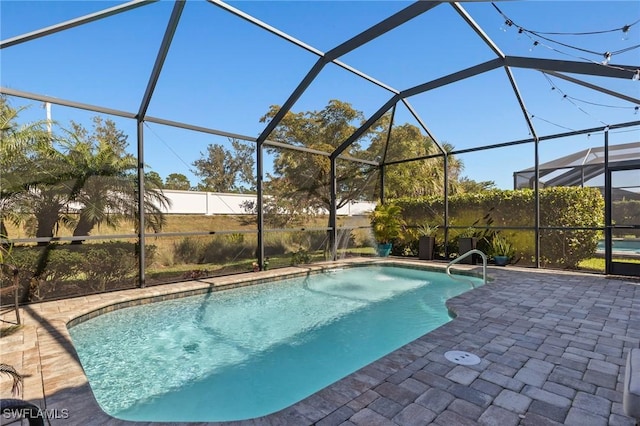 view of pool with glass enclosure and a patio area