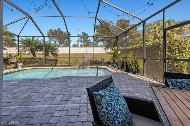 view of pool featuring pool water feature, a patio, and glass enclosure