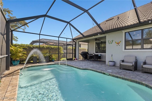 view of pool featuring ceiling fan, glass enclosure, and a patio area