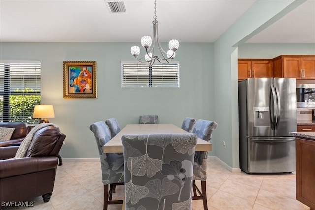 tiled dining room with a notable chandelier