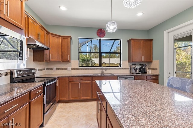 kitchen with stainless steel appliances, hanging light fixtures, sink, and decorative backsplash