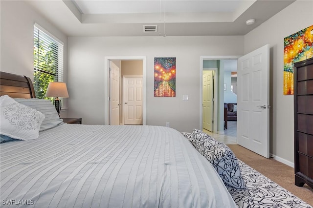 carpeted bedroom with a tray ceiling