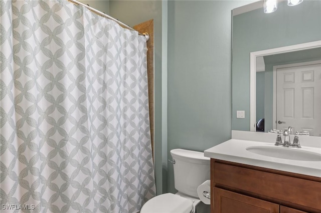 bathroom with vanity, toilet, and walk in shower