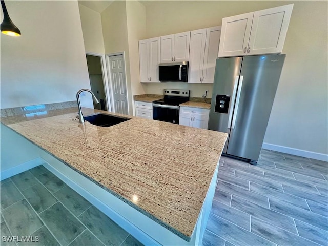 kitchen featuring appliances with stainless steel finishes, sink, white cabinets, and kitchen peninsula