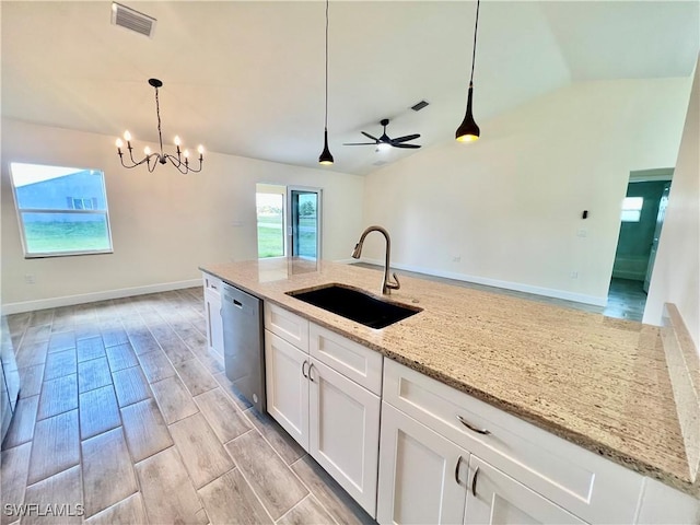 kitchen with decorative light fixtures, white cabinetry, dishwasher, sink, and light stone counters