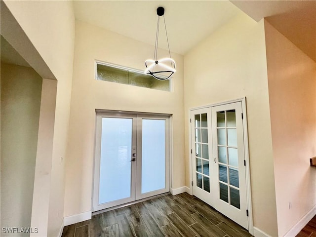 interior space featuring french doors, a towering ceiling, and dark hardwood / wood-style floors