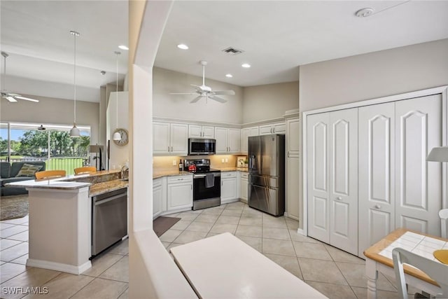 kitchen with pendant lighting, ceiling fan, appliances with stainless steel finishes, white cabinets, and kitchen peninsula