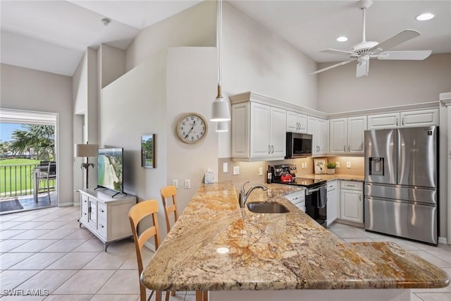 kitchen with sink, a breakfast bar area, appliances with stainless steel finishes, white cabinetry, and kitchen peninsula