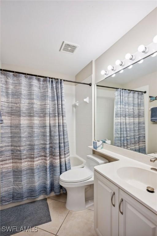 full bathroom featuring shower / bathtub combination with curtain, tile patterned floors, toilet, and vanity