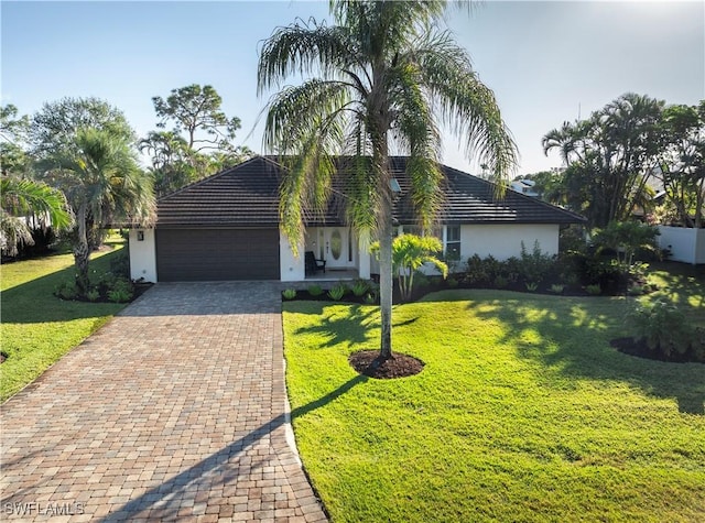 ranch-style house with a garage and a front lawn