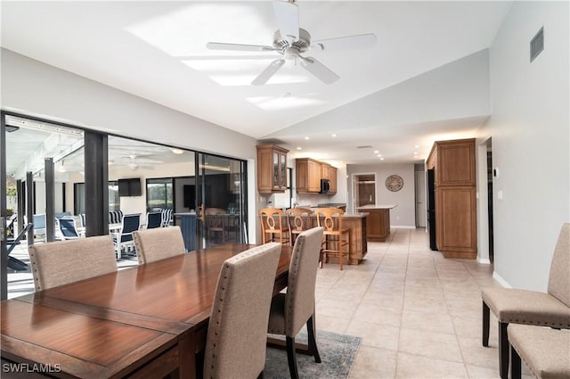 tiled dining room with vaulted ceiling and ceiling fan