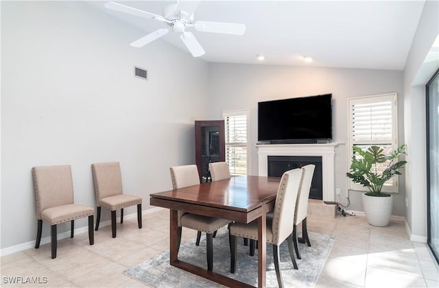 dining space with ceiling fan, lofted ceiling, and light tile patterned floors